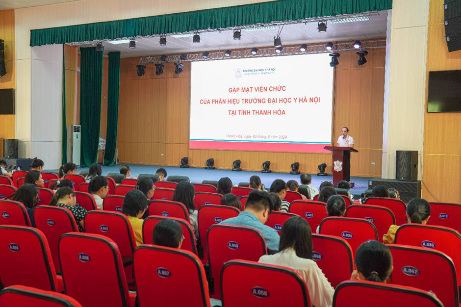 A person standing at a podium in front of a large screenDescription automatically generated